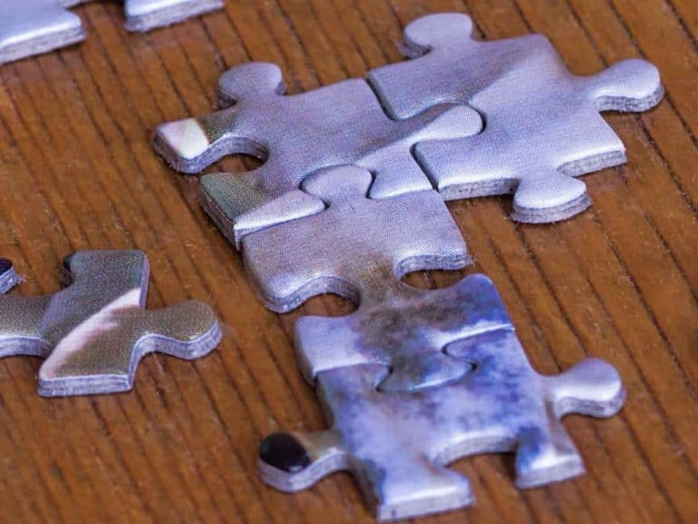 Close-up of jigsaw puzzle pieces on wooden table.
