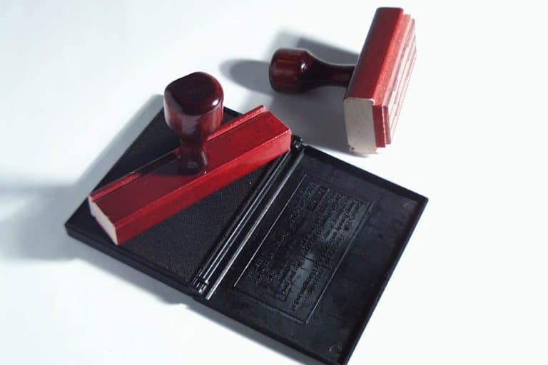 Red wooden stamps and ink pad on white background.