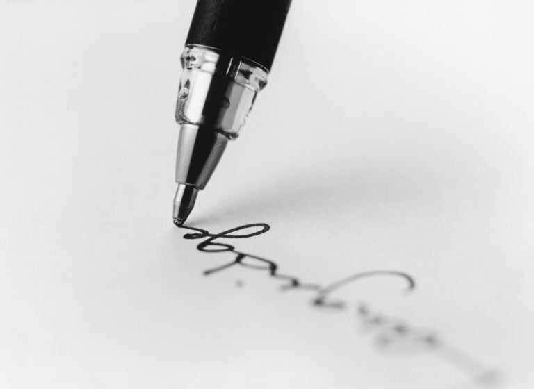 Close-up of pen writing on paper.